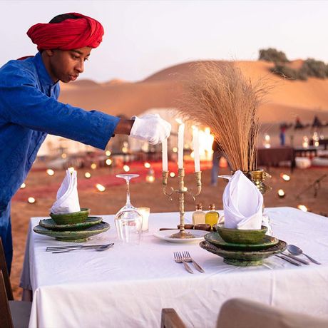 Blick auf einen gedeckten Tisch zum Abendessen im Aussenbereich des Wuestencamps Luxus (Erg Chebbi)