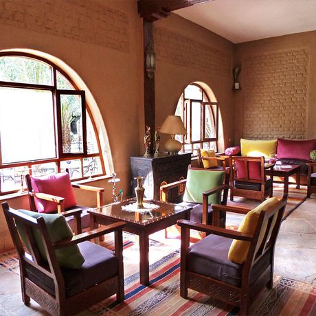 Blick auf Sessel und Tische im Innenbereich des Kasbah-Hotels la Rose du Desert