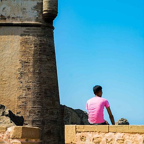 Person auf Stadtmauer mit Turm
