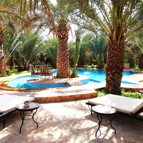Blick auf Liegen und Palmen am Pool des Kasbah-Hotels la Rose du Desert