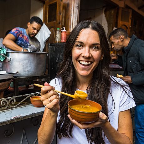 Kulinarische Tour - Medina Marrakech Galerie Frau isst Suppe an einem Streetfood-Stand