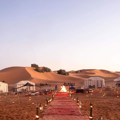 Blick auf einen Weg zur Feuerstelle und die Schlafzelte im Wuestencamp Luxus (Erg Chebbi)