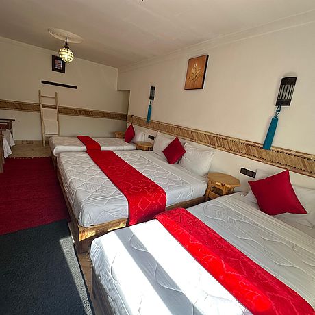 Blick auf zwei Einzelbetten und ein Doppelbett