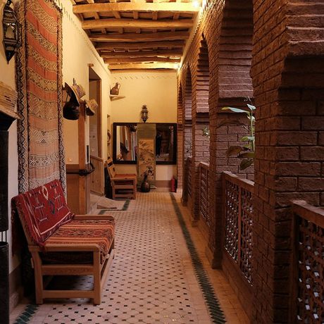 Blick auf Sitzbaenke und Dekoration auf einer oberen Ebene des Patios des Hotels Dar Jnan Tiouira