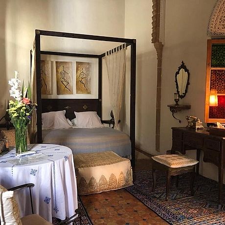 Schlafzimmer mit Himmelbett, Schreibstisch und Tisch