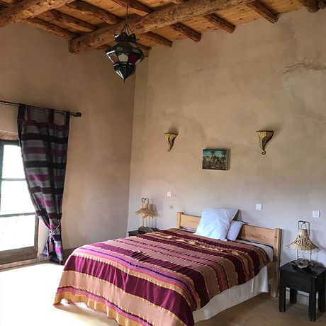 Blick auf ein Bett im Standardzimmer in der Kasbah Timdaf