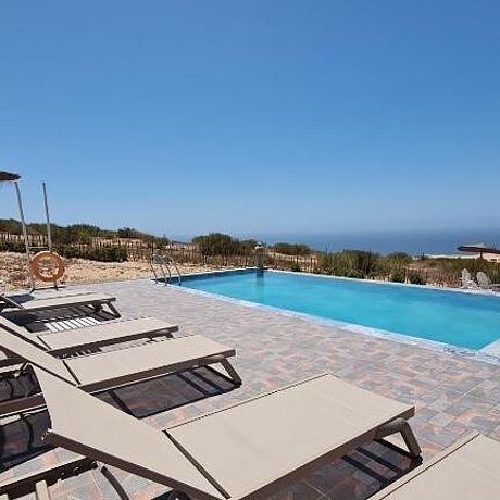Sonneliegen am Pool mit Blick aufs Meer