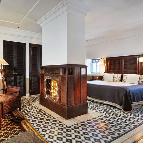 Schlafzimmer mit Bett und Kamin in einer Suite Premium