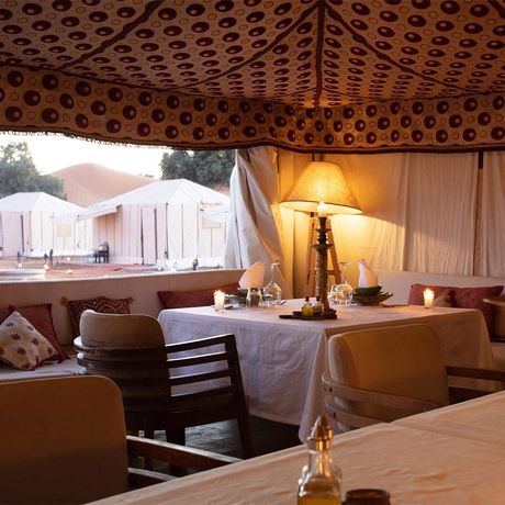 Blick auf gedeckte Tische im Restaurant des Wuestencamps Luxus (Erg Chebbi)