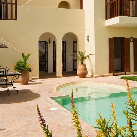 Pool mit Bungalow und Tisch