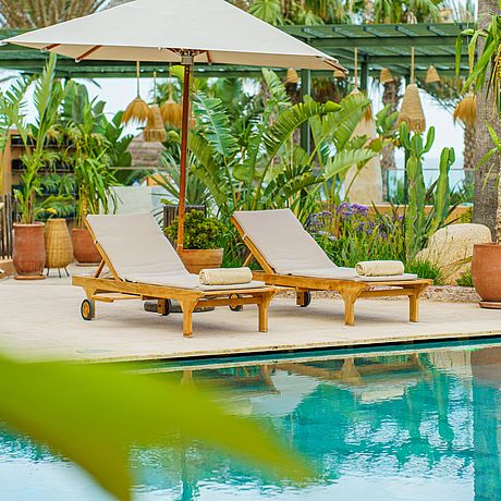Sonnenliegen am begrünten Pool
