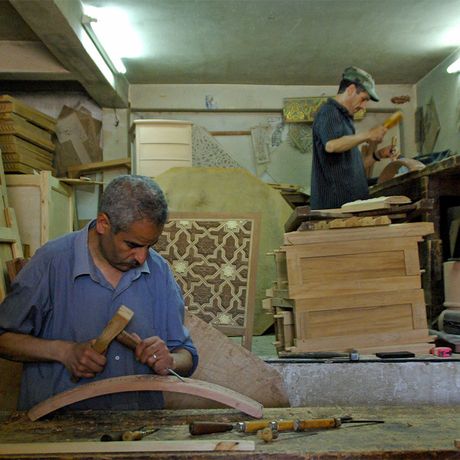 Blick auf zwei Personen, die Holz verarbeiten